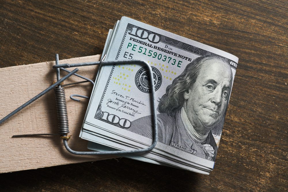 Image of a mouse trap with money clipped inside